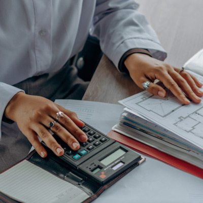 Comptable utilisant une calculatrice pour vérifier des documents financiers, illustrant les pratiques comptables de base