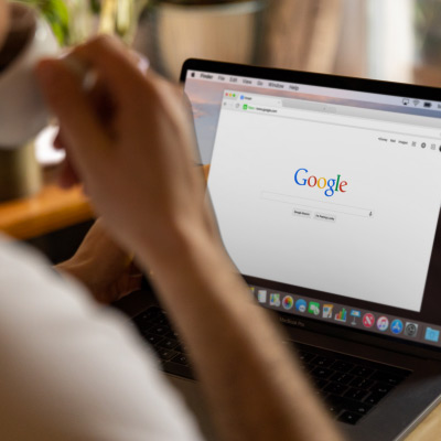 Professionnel utilisant Google sur un ordinateur portable pour rechercher des informations, illustrant l'utilisation des outils collaboratifs de Google Workspace